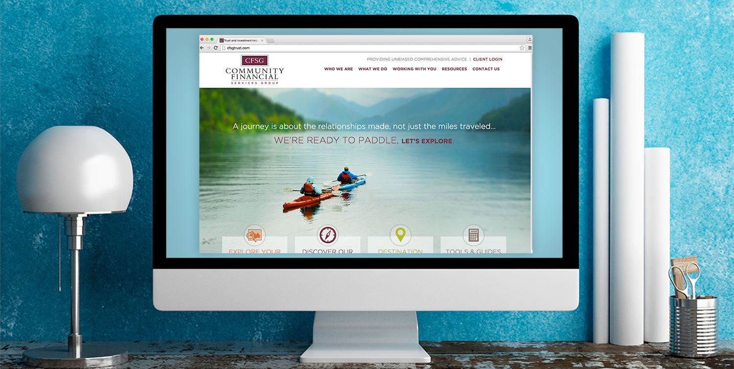 Desktop computer displaying the Community Financial Services Group responsive website design.