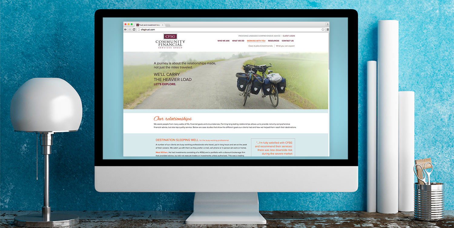 Desktop computer displaying the Community Financial Services Group responsive website design.