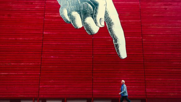 Animated giant hand pointing at a man walking to represent that custom websites are better than templated websites.